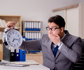 Businessman with clock failing to meet deadlines