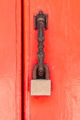 The padlock hangs on the red wooden door