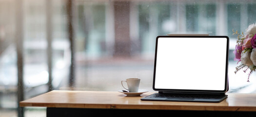 Blank screen Laptop computer and poster workspace background in modern office