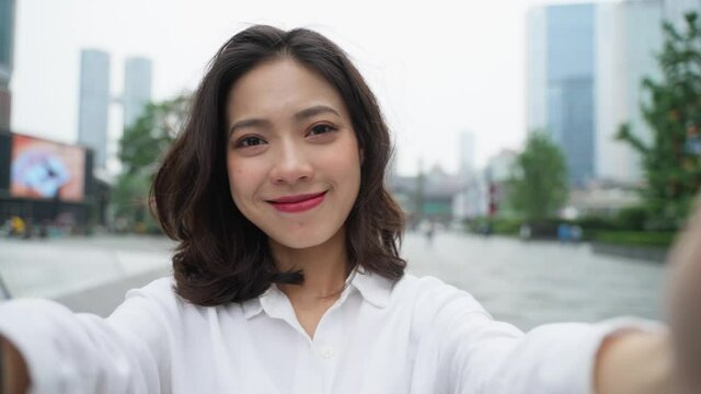 happy young asian woman close up portrait slow motion charming Chineses lady lovley girl looking at camera smile in the urban city street  POV view holding girlfriend 