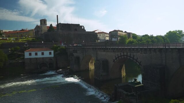 Medieval bridge with a old palace in ruins, a river and a house in the city of Barcelos, Portugal
