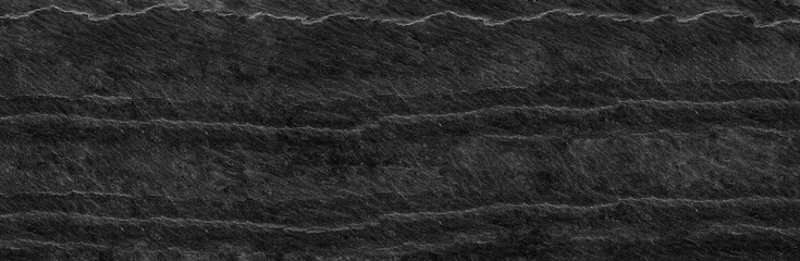 Fototapeta premium Panorama dark gray stone background with copy space. Black grunge banner with rock texture.