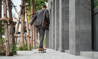 lifestyle businessman in suit riding on skateboard along street