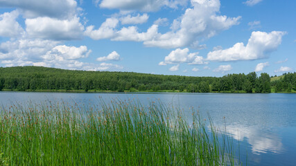 Clouds and blue skies are reflected in the water. Beautiful Lake Singgol, summer, Siberia Krasnoyarsk Territory