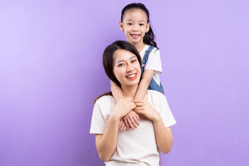 Portrait of Asian mother and daughter on purple background