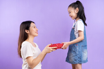Portrait of Asian mother and daughter on purple background