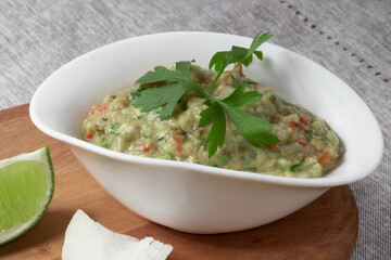 Mexican food guacamole in a white bowl close up.