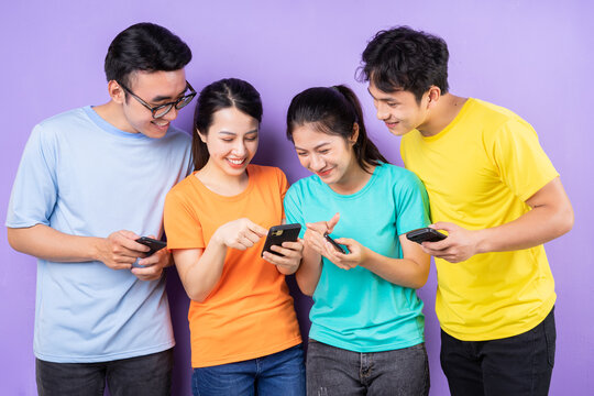Asian Best Friend Group Using Cell Phone On Purple Background