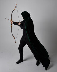 Full length portrait of a  brunette man wearing black shirt, waistcoat and a green velvet cloak...