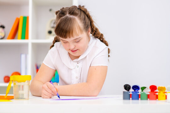Beautiful girl with Down Syndrome works at home