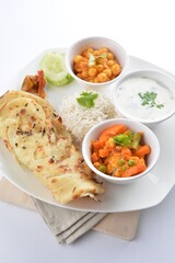 Indian baked roti prata canai with curry vegetables, yogurt sauce, pea bean and steamed white rice in white background asian vegan halal menu