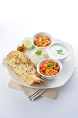 Indian baked roti prata canai with curry vegetables, yogurt sauce, pea bean and steamed white rice in white background asian vegan halal menu