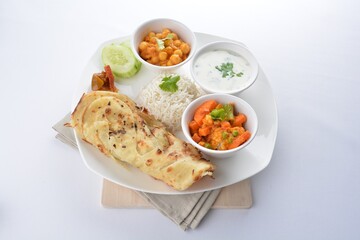 Indian baked roti prata canai with curry vegetables, yogurt sauce, pea bean and steamed white rice in white background asian vegan halal menu