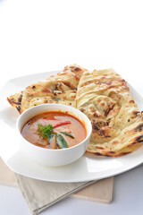 indian roti prata canai 2 pieces with spicy curry chicken gravy soup in bowl in white background asian halal menu