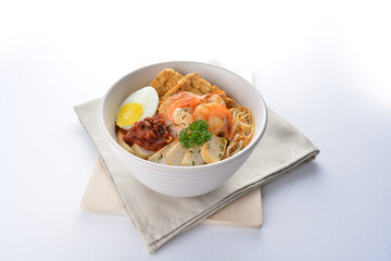 spicy nyonya noodle laksa soup with seafood prawn, fish cake, egg, bean curd and chilli sambal sauce in white background asian halal menu
