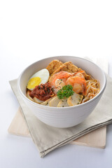 spicy nyonya noodle laksa soup with seafood prawn, fish cake, egg, bean curd and chilli sambal sauce in white background asian halal menu