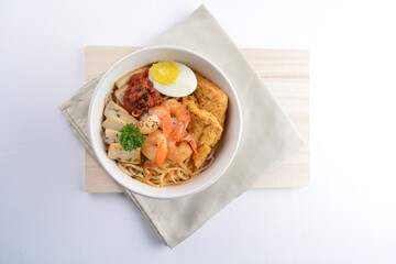 spicy nyonya noodle laksa soup with seafood prawn, fish cake, egg, bean curd and chilli sambal sauce in white background asian halal menu