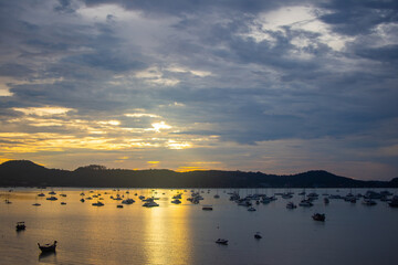 beautiful sunrise with boat on the sea summer at Chalong bay, Phuket province, Thailand. subject is blurred noise and low key.