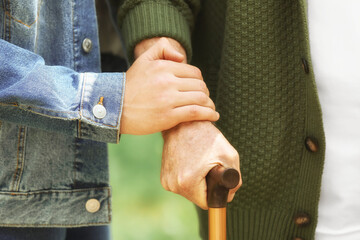 Fototapeta premium Hands of elderly and young men outdoors, closeup. Concept of nursing home