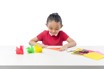 Asian little girl folding a paper