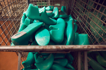 Closeup shot of pile of shoe lasts at shoe making factory. Lots of green plastic shoe lasts in...