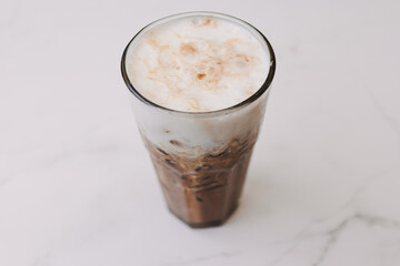 Iced cappuccino coffee drink in a tall glass. Concept of summer refreshment drink.