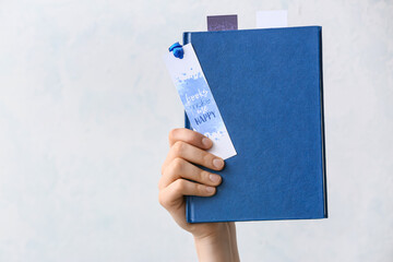 Woman with bookmark and book on white background