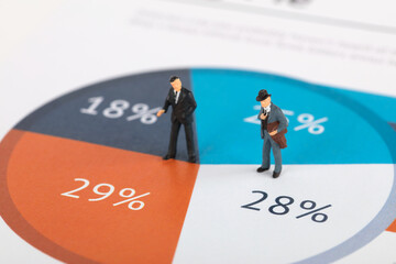 Miniature businessman doll standing on digital pie chart