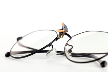 Miniature doll reading a book in glasses