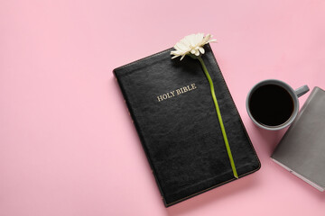 Holy Bible, cup of coffee and flower on color background