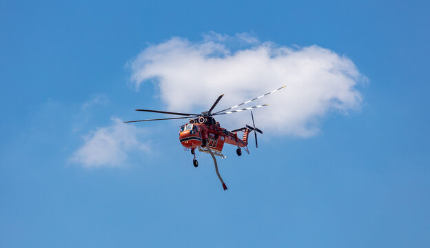 Greek fire brigade Erickson helicopter  returning to airport after a mission, blue sky background