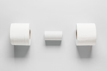 Rolls of toilet paper and cardboard tube on grey background