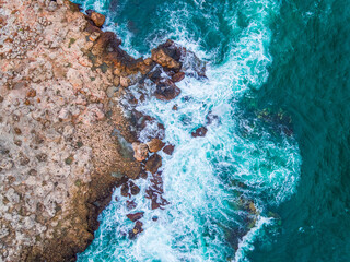 Aerial view of rocky coastline and crashing waves