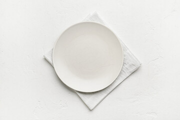 Fabric napkin and plate on light background