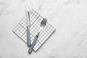 Fabric napkin and cutlery on light background