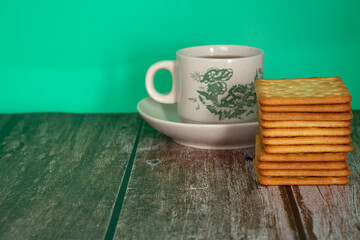 Fototapeta na wymiar Breakfast serving of cream crackers and a cup of tea. Selective focus points. Blurred background