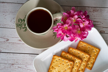 Breakfast serving of cream crackers and a cup of tea. Selective focus points. Blurred background