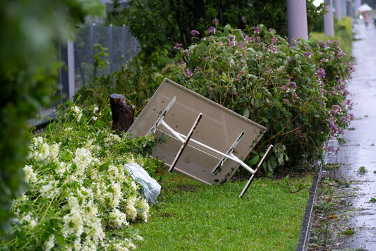 Blown away white garden table after heavy nightly summer thunderstorm at City of Zurich. Photo taken July 13th, 2021, Zurich, Switzerland.