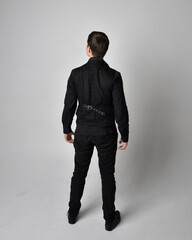 Full length portrait of a brunette man wearing black shirt and gothic waistcoat.  Standing pose...