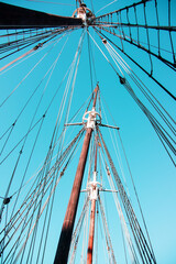 Masts with rigging on a cruise yacht rushing up to the blue sky. Active leisure concept