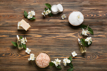 Frame made of cosmetic products and jasmine flowers on wooden background