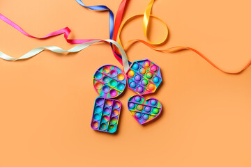 Pop it fidget toys and ribbons on color background