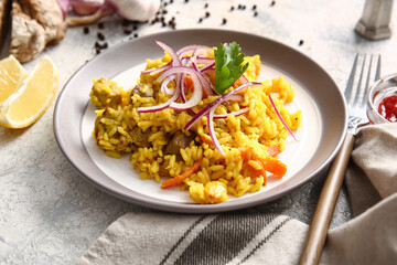 Plate with tasty pilaf on light background