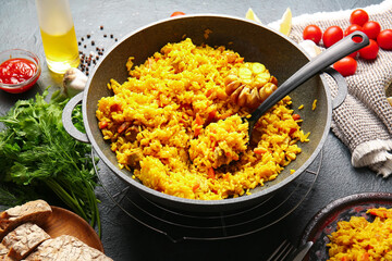 Composition with tasty pilaf on dark background