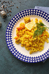 Plate with tasty pilaf on dark background