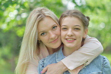 happy mother with her daughter hugging a teenager in the summer. Caring happy mother enjoy day with...