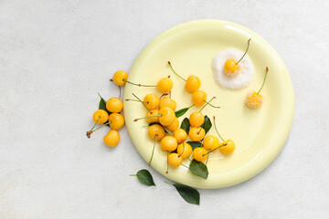 Plate with tasty sweet cherries and sugar on light background