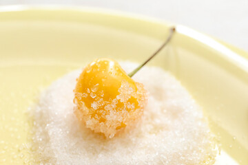 Plate with tasty sweet cherry and sugar on light background