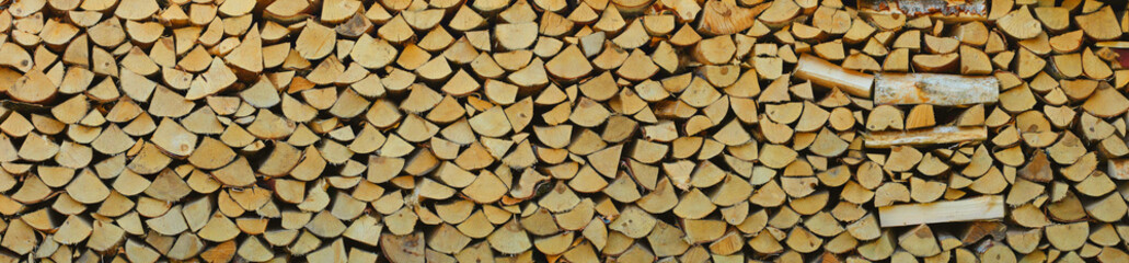 Firewood, stacked in piles, prepared for the cold winter. Background photo.