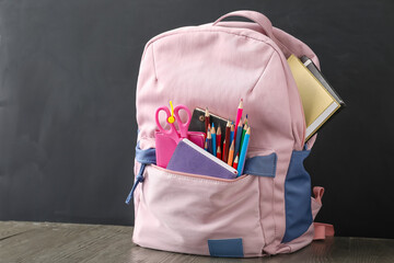 School backpack and stationery near blackboard © Pixel-Shot